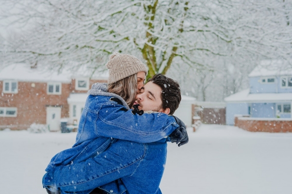 man and woman hugging on snow field