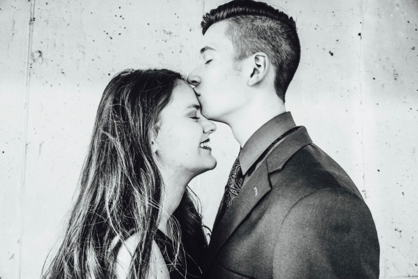 grayscale photo of man kissing woman